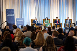 Michael Drummond, Maggie Ayrea, Carter Farmer, and Chad Whiteman sit on stage for a fireside chat.