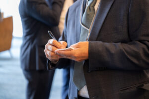 An attendee writes on a sticky note.