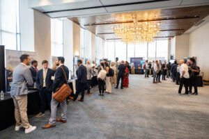 Attendees network at exhibitor tables on the demo floor.